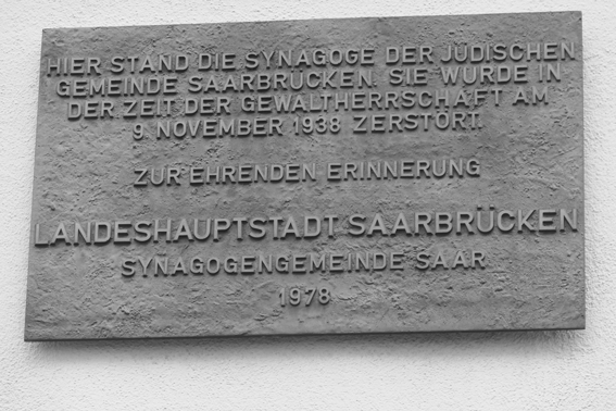 In der Futterstraße gibt es eine Tafel, die an den Standort der ehemaligen Synagoge erinnert. An einer Säule in der Arkade hängt ein Hinweisschild, Foto: Manfred Weiss