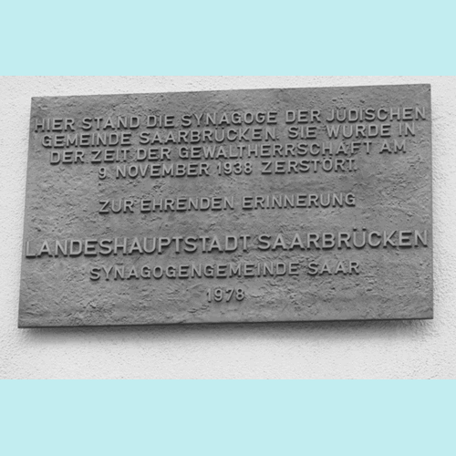 In der Futterstraße gibt es eine Tafel, die an den Standort der ehemaligen Synagoge erinnert. An einer Säule in der Arkade hängt ein Hinweisschild, Foto: Manfred Weiss