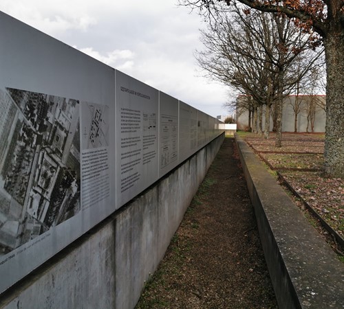 Innenseite der Mauer mit Informationen zur Geschichte des ehemaligen Lagers